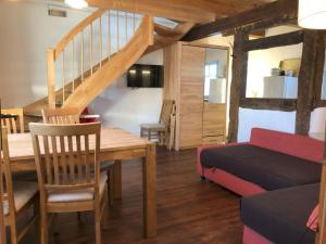 een woonkamer met een tafel, een bed en een trap bij Hirtenwohnung im Arbeiterhaus in Braunsberg