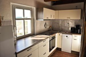 een keuken met witte kasten en witte apparaten bij Hirtenwohnung im Arbeiterhaus in Braunsberg +3 foto's