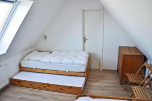 een zolderkamer met twee bedden en een raam bij Hirtenwohnung im Arbeiterhaus in Braunsberg