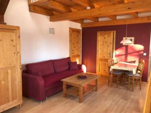een woonkamer met een paarse bank en een tafel bij Ferienwohnung Wandersruh in Braunsberg