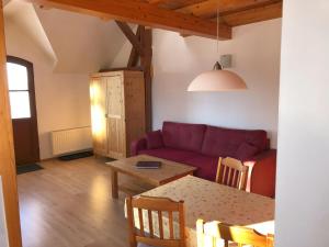 een woonkamer met een paarse bank en een tafel bij Ferienwohnung Wandersruh in Braunsberg