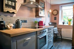 een keuken met een aanrecht en een fornuis bovenste oven bij Finest Retreats - Flittermouse Cottage in Wingfield