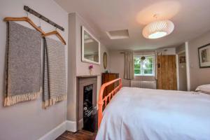 een slaapkamer met een groot bed en een open haard bij Finest Retreats - Flittermouse Cottage in Wingfield