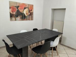 une salle à manger avec une table et des chaises noires dans l'établissement Casa Ciuccetti, à Baldichieri 5 autres photos