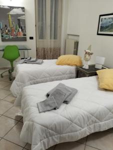 - une chambre avec deux lits et une chaise verte dans l'établissement Casa Ciuccetti, à Baldichieri