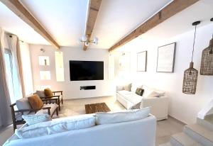 a living room with white furniture and a flat screen tv at Maison Massilia Duclaux in Marseille