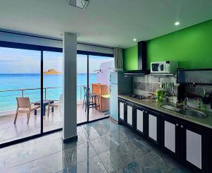 a kitchen with green walls and a view of the ocean at Dream View Nova in Rafrāf