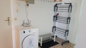 een wasruimte met een wasmachine en een plank bij Süder11 - ApartB in Eddelak