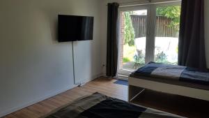 een slaapkamer met een bed en een glazen schuifdeur bij Süder11 - ApartB in Eddelak