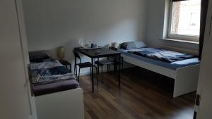 een kamer met twee bedden, een tafel en een raam bij Süder11 - ApartB in Eddelak