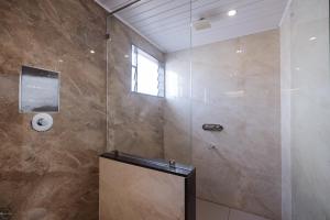 een badkamer met een douche met een spiegel en een raam bij Reunion De Homes - Premium Suites in Udupi +19 foto's