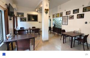 a dining room with wooden tables and chairs at Iora Guest House in Bharatpur