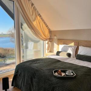 ein Schlafzimmer mit einem Bett, auf dem ein Tablett mit Essen steht in der Unterkunft SEN TOPOLI Domy nad jeziorem 