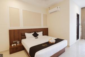 een slaapkamer met een groot bed en een zwart-wit dekbed bij Reunion De Homes - Premium Suites in Udupi