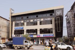 een man op een motor voor een gebouw bij Reunion De Homes - Premium Suites in Udupi