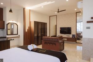 een slaapkamer met een groot bed en een televisie bij Reunion De Homes - Premium Suites in Udupi