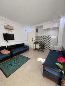 Al Ḩārah al KabīrahR feto house的客厅里有一张沙发和一台电视