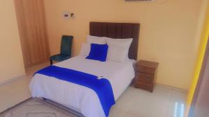 Un dormitorio con una cama y una silla azul. en kiddy, en Mogwase