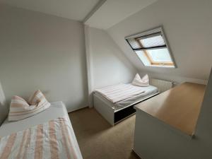 ein kleines Zimmer mit zwei Betten und einem Fenster in der Unterkunft Ferienwohnung Serbitz in Treben