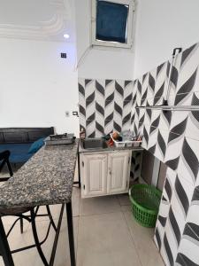 Al Ḩārah al KabīrahR feto house的厨房配有柜台、水槽和桌子