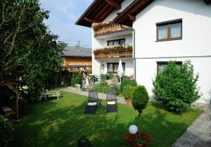 a house with a yard with two chairs in it at Haus Stuttgart in Obernberg am Inn