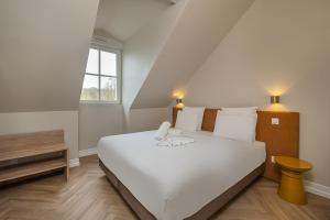 Postel nebo postele na pokoji v ubytování L'Horloge - Appart'Hotel proche de Disneyland