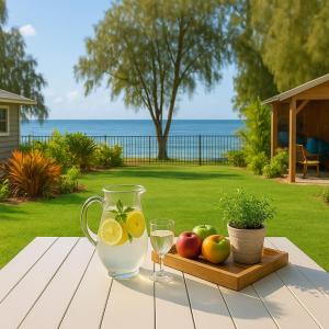 una mesa de madera con una bandeja de frutas y copas de vino en Berkeley Waterfront - Family & Pet Paradise, en Berkeley Vale