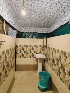 een badkamer met een wastafel en een muur met bloemen bij the jungle book - luxury camps by lake & woods in Bhīm Tāl