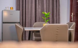 a table and chairs with a plant on top of it at Afro-D Apartment in Asagba