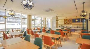 a cafeteria with tables and chairs and a kitchen at City Comfort Inn Kunming Nanping Pedestrian Street Wangfujing in Kunming