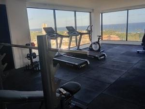 a gym with cardio equipment and a view of the ocean at Full Studio in Stella Maris in Salvador