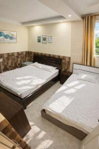 two twin beds in a room with a window at Lucky 1 Hotel in Trà Vinh +35 photos