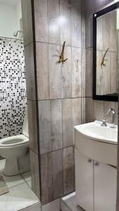 ein Badezimmer mit einem Waschbecken und einem WC mit Vögeln an der Wand in der Unterkunft Hospedaje Golden  + 23 Fotos