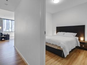 een slaapkamer met een bed en een woonkamer bij Serenity One Boutique in Melbourne