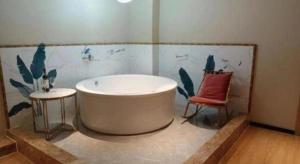 a bathroom with a bath tub and a chair at Magnotel Shenyang Consulate Qingnian Street in Shenyang +103 photos