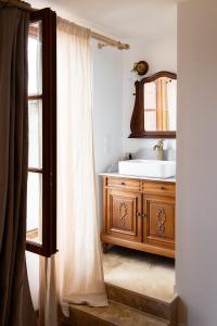 un bagno con lavandino e specchio di L'Auberge des Clés a Chevannes