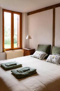 two towels are sitting on a bed in a bedroom at L'Auberge des Clés in Chevannes