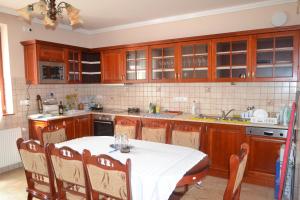 a kitchen with a table with a white table cloth at Módos Falusi Szálláshely in Bihartorda +15 photos