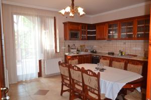 a kitchen with a table with a white table cloth at Módos Falusi Szálláshely in Bihartorda