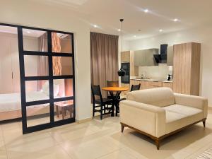 a living room with a couch and a table and a kitchen at AfricaWorks Suites in Dakar