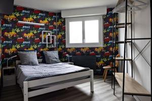 a bedroom with a bed with a colorful wallpaper at splendide in Chalon-sur-Saône