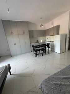 une cuisine blanche avec une table et des chaises dans l'établissement Mpalaskas luxury apartments, à Vonitza