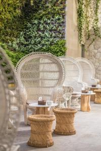 a group of wicker chairs and tables on a patio at Hotel Cap Negret in Altea