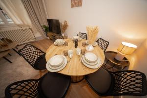 a dining room with a wooden table and chairs at L'Élégance - Cozy & Parking in Chambéry