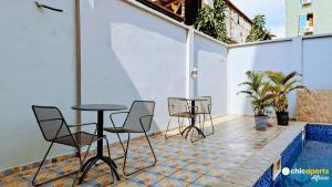 eine Terrasse mit Stühlen und Tischen neben einem Pool in der Unterkunft Chic studio with parking and pool in Douala