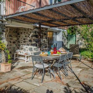 ein Tisch und Stühle unter einem Sonnenschirm auf einer Terrasse in der Unterkunft Villa La Pavona Luxury Collection in Monterosso al Mare + 43 Fotos