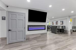 ein großes Zimmer mit Fernseher und Tür in der Unterkunft Days Inn & Suites by Wyndham Texas City in Texas City