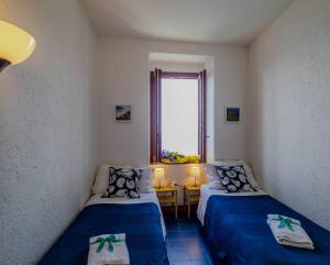 En eller flere senge i et værelse på La Lampara Sea View Terrace Apartment with AC