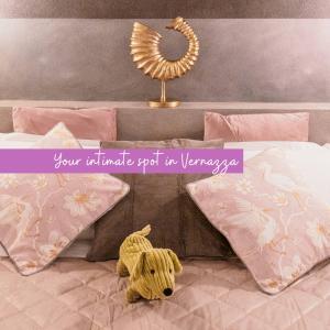 een knuffelbeer op een bed met kussens bij Camaella Luxury Studio in Vernazza