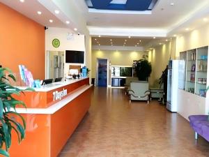 an office lobby with an orange counter and chairs at 7 Days Inn Shenyang Gugong Middle Street Pedestrian Street in Shenyang